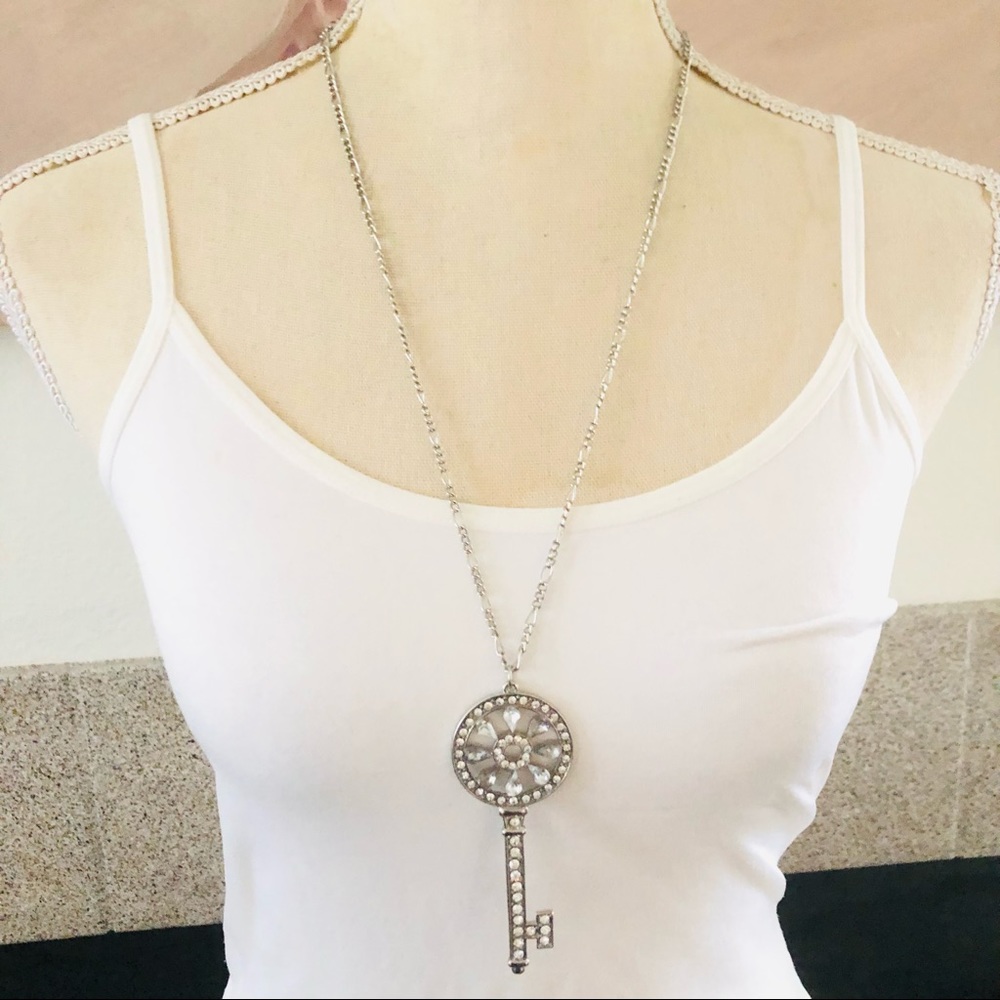 Clear rhinestone skeleton key pendant on Figaro chain necklace